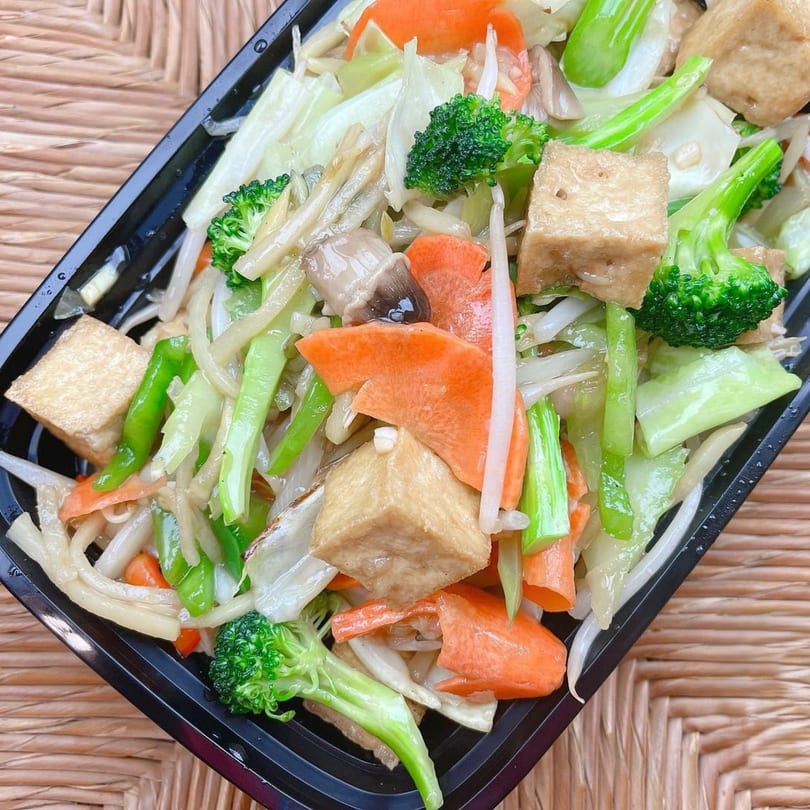 Barnrau Thai Halal Cuisine's stir-fried vegetables with tofu, broccoli, carrots, and cabbage in a black container.